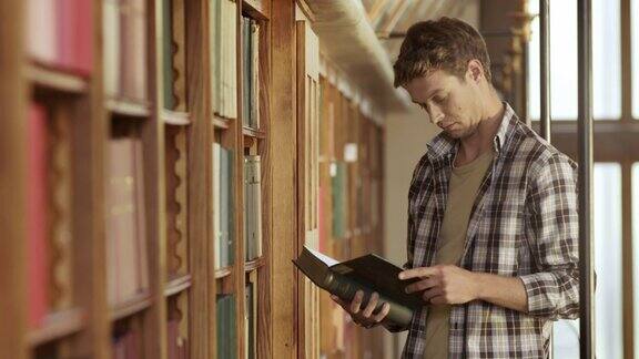 一个年轻人在图书馆里翻看一本书