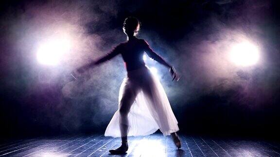黑暗舞台上一个跳跃的芭蕾舞女演员的剪影