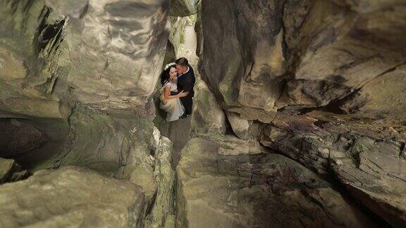 新郎和新娘站在山洞里相爱的新婚夫妇