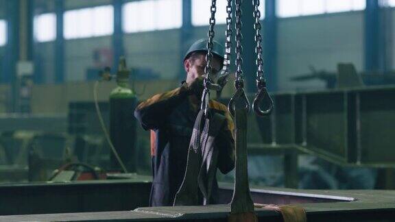 工厂里的重工业工人正在遥控操作起重机