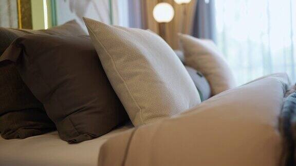 特写镜头拍摄多利的软枕靠垫安排设置在白色的卧室家居室内细节设计背景家居室内设计理念美丽的卧室与光窗帘窗场景