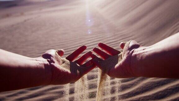 女性手中握着干热的沙漠沙粒
