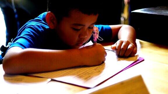 亚裔孩子穿着学生校服做读书写字的学校作业