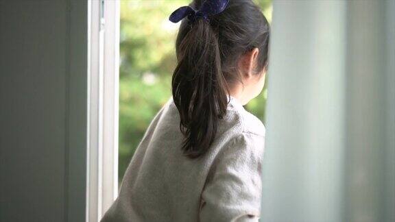 小女孩望着窗外