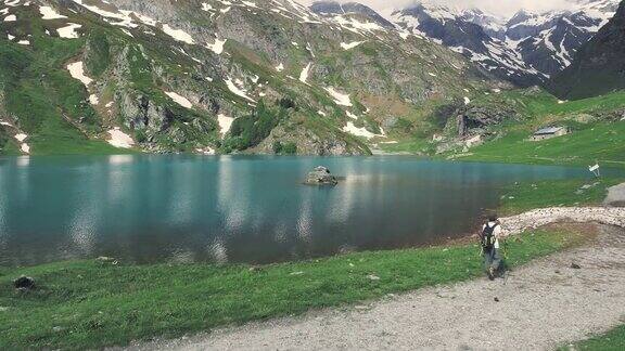 在阿尔卑斯山的蓝色湖泊徒步旅行的女人