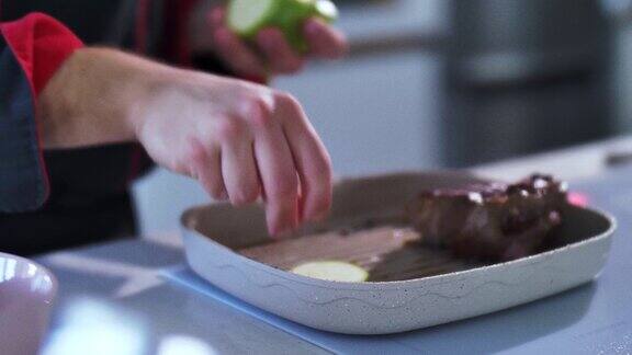 厨师在烤盘里倒入橄榄油在上面放上西葫芦片