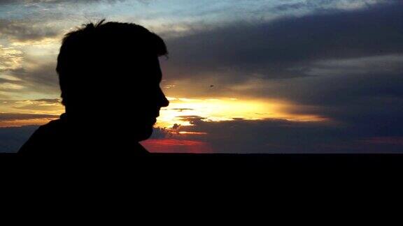 男人在夕阳下剪影男人望着天空思考着人生回忆着