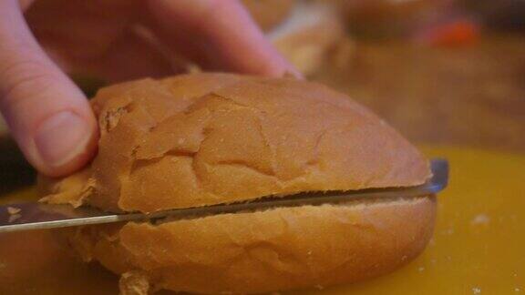 在家做汉堡在桌子上切面包卷