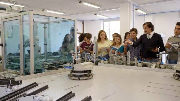 年轻的学生从老师那里学习机器人