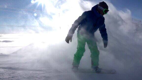 慢动作:滑雪者在山坡上喷洒刚清理过的雪
