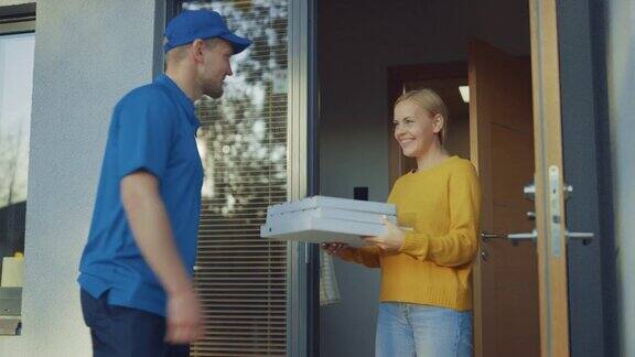 美丽的年轻微笑的女人打开家门遇到了送披萨的人他给了她满满一箱美味的蒸披萨