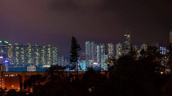 夜晚照亮了香港城市的公寓大楼全景4k的时间推移