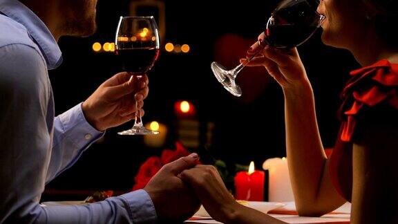 热恋中的情侣聊天喝红酒惬意地庆祝情人节