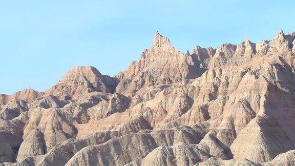 AERIAL:在BadlandsNP陡峭的砂岩山脉映衬着湛蓝的天空