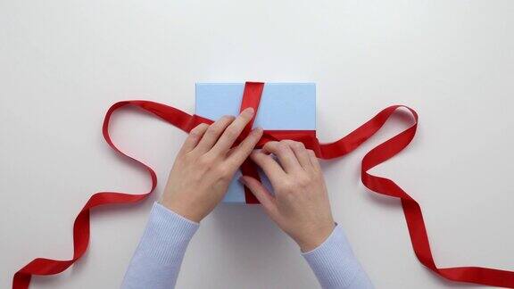 空中拍摄的女子打开礼物上的红丝带