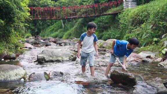男孩们在小溪里钓鱼