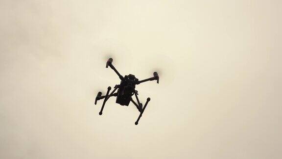 一架带着摄像机的无人直升机盘旋在空中现代军用无人机