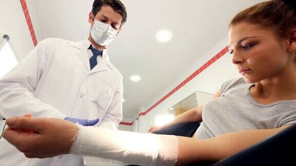 一位专业的医生正在给一个女孩的手臂包扎