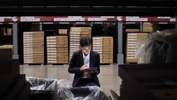 亚洲女商人使用数字平板电脑在仓库检查产品库存