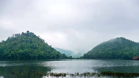 时间流逝视频美丽的湖在双山前与雾和多云的天空