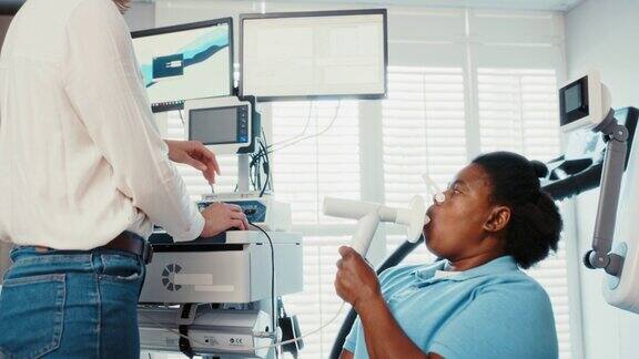 医生在医院给轮椅病人做肺容量测试运用数据分析、技术检查残疾妇女的肺功能检测冠状病毒感染后的最佳血氧水平