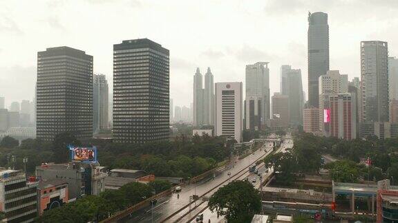 在印度尼西亚雅加达的一个雨天空中摄影车飞过一条多车道的道路进入城市