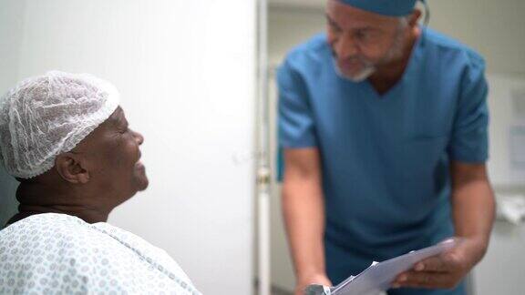护士在医院里与一位女老年病人交谈并给予情感支持