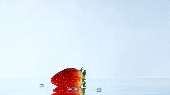 草莓落下和在水上滚动的慢镜头
