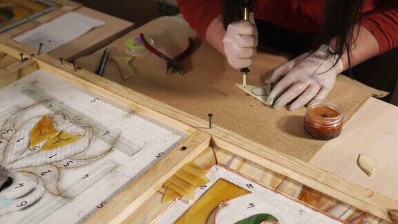 师傅正在切割一小块玻璃用来制作装饰板的图案