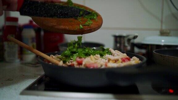 在烹饪平底锅中加入意大利面和蔬菜女士加入生菠菜以获得完整的口感