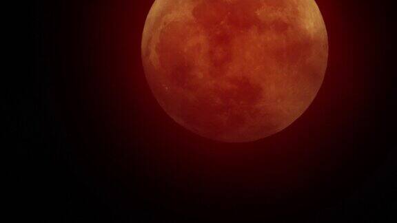 红色的月亮在红色的天空中移动乌云遮住了月亮