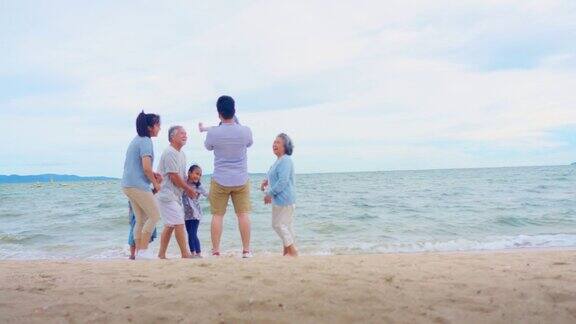 亚洲大家庭在沙滩上冲浪