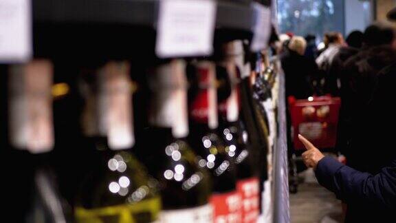 购买者在葡萄酒和伏特加部的超市货架上选择酒精饮料