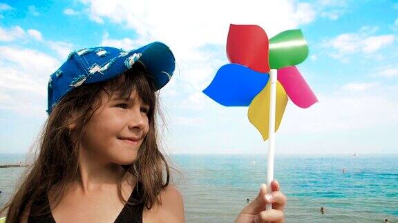 在沙滩上玩风车的快乐女孩