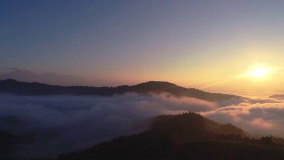 空中日出在山顶和森林上空的雾斯洛文尼亚
