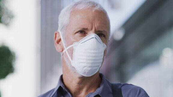 一名白人男子戴着口罩在街上走动以抵御冠状病毒