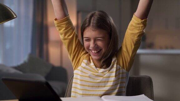 一个小女孩在家做作业庆祝自己的成就的4k视频片段