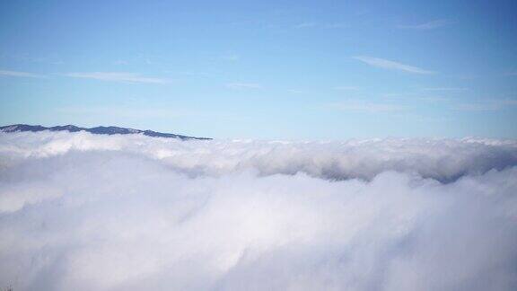 从空中俯瞰浓雾像美丽的云海和云上的山峰太阳从无边无际的云海中冉冉升起直到地平线