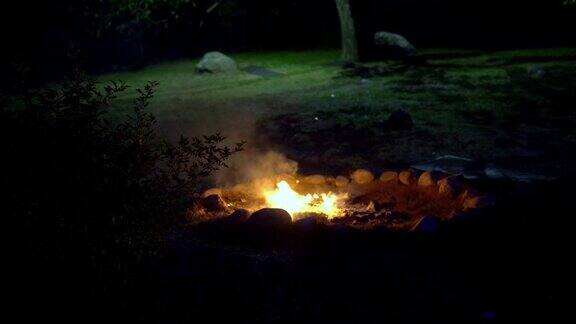 山间自然旅游营地的篝火火焰和火焰火花在黑暗抽象的背景