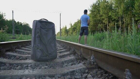 男子把袋子放在铁路上跑到草地上小便
