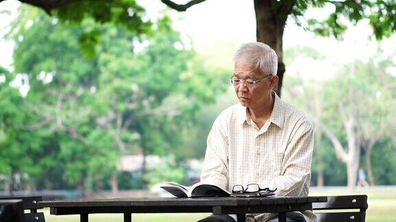 亚洲老人独自在公园看书