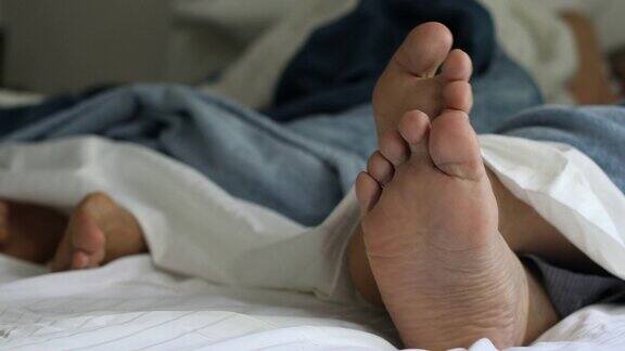 男人把脚放在床上休息