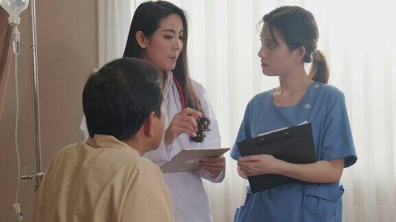 亚洲女医生和护士来到检查室向坐在康复室床上的男病人询问健康问题女医生讨论并给男人保健建议