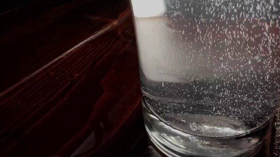 在清澈的小玻璃杯里冒着泡背景是黑色的
