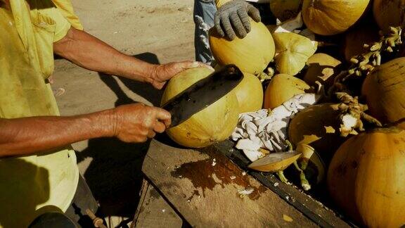 椰子街小贩正在用斧头砍椰子