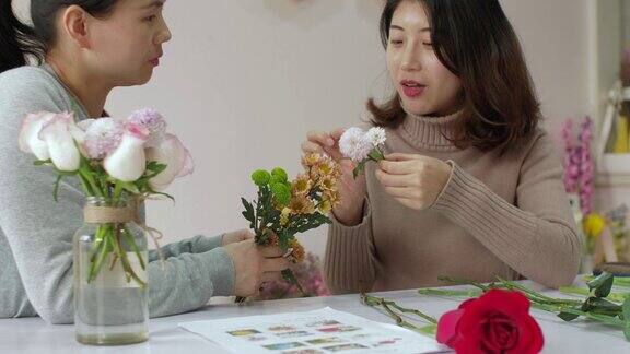 女孩花商正在训练她的朋友如何制作漂亮的花束