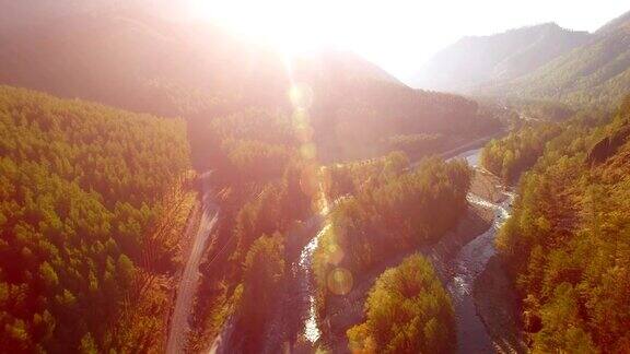 在阳光明媚的夏日清晨空中飞过新鲜的山河和草地下方乡村土路
