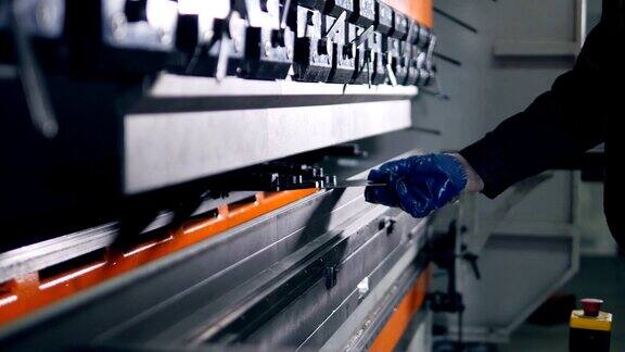 工人在工厂的现代弯曲工业机器上弯曲金属板
