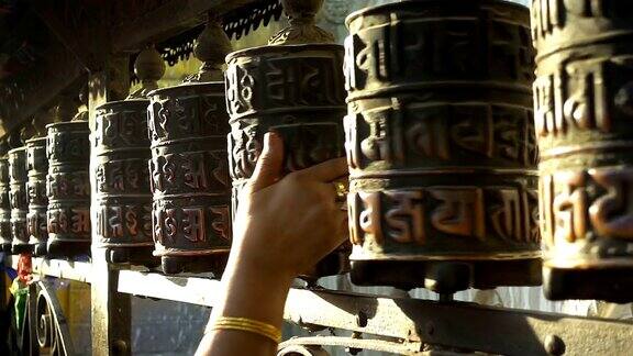 在尼泊尔加德满都的斯瓦扬布纳特塔上转动祈祷轮