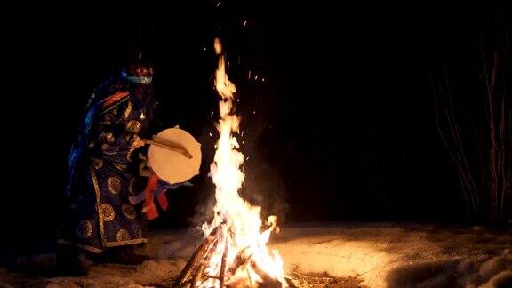 萨满围绕着火堆演奏手鼓跳舞